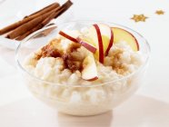 Rice pudding with cinnamon and apple slices — Stock Photo