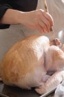 Человеческая рука чистит индейку маринадом — стоковое фото
