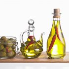 Olive con bottiglie di olio di peperoncino ed erbe aromatiche — Foto stock
