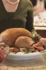 Woman with roast turkey in kitchen — Stock Photo
