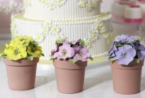 Wedding cake and artificial pansies — Stock Photo