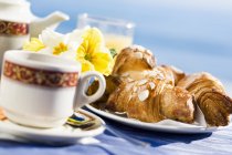 Tea and three almond croissants — Stock Photo