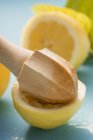 Metade espremida de limão com espremedor de frutas cítricas — Fotografia de Stock