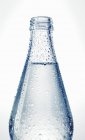 Vista da vicino della bottiglia di vetro bagnato di acqua — Foto stock