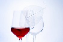 Copa de vino tinto y copa de vino vacía - foto de stock