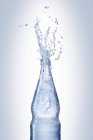 Water splashing out of bottle — Stock Photo
