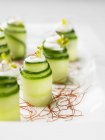Cucumber rolls on saffron  on white plate — Stock Photo