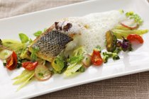 Fried sea bass with spring vegetables — Stock Photo