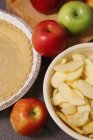 Closeup view of whole and sliced apples with pie crust — Stock Photo