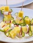 Cheese on cocktail sticks on plate — Stock Photo