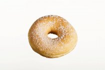 Donut açucarado na mesa branca — Fotografia de Stock