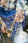 Nahaufnahme einer Frau, die Tee von Tasse zu Tasse gießt — Stockfoto