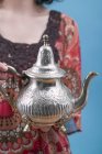 Vue rapprochée de la femme tenant une théière en métal — Photo de stock