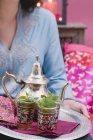 Closeup view of woman serving peppermint tea on tray — Stock Photo