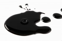Пятно черного бальзамического соуса на белой поверхности — стоковое фото