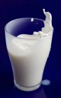 Milk splashing out of glass — Stock Photo