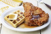 Nahaufnahme von Waffeln und gebratenem Huhn mit Ahornsirup und Butter — Stockfoto