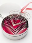 Closeup view of heart-shaped biscuit cutters and hanger with ribbon — Stock Photo