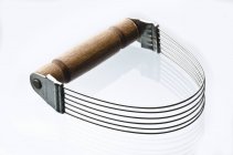 Vista close-up de um cortador de pastelaria de metal com cabo de madeira em uma superfície branca — Fotografia de Stock