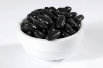 Haricots noirs dans un bol en céramique — Photo de stock