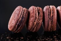 Row of chocolate macaroons — Stock Photo