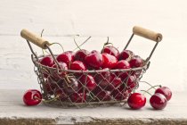 Cherries in wire basket — Stock Photo
