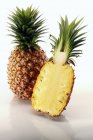 Whole and halved pineapples — Stock Photo