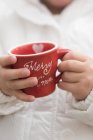 Closeup view of child holding red Christmas cup — Stock Photo