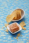 Elevated view of fish and chips in white dishes on patterned blue surface — Stock Photo