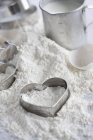 Closeup view of baking ingredients and heart-shaped cookie cutters — Stock Photo