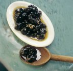 Marinated black olives with mustard seeds — Stock Photo