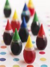 Primo piano vista di bottiglie coloranti alimentari su superficie punteggiata — Foto stock