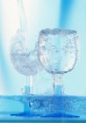 Wasser in Gläser gießen — Stockfoto