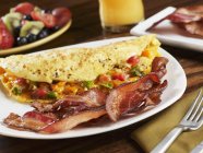 Tiras de bacon defumado com omelete vegetariana — Fotografia de Stock