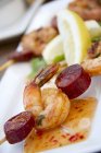 Vista close-up de Chorizo e espetos de camarão com molho doce e azedo — Fotografia de Stock