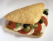 Sesame roll filled with tomato — Stock Photo