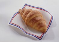Croissant fresco su tovagliolo — Foto stock
