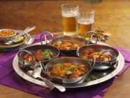 Vue surélevée de quatre types différents de currys sur un plateau — Photo de stock