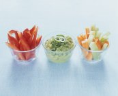 Bâtonnets de légumes avec guacamole dans des verres sur fond bleu — Photo de stock