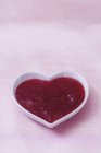 Strawberry jam in heart-shaped dish — Stock Photo