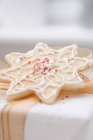 Star-shaped biscuit on Christmas parcel — Stock Photo