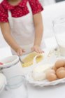 Tilted view of girl flattening dough with hands — Stock Photo