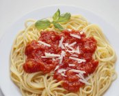 Espaguetis con salsa de tomate y parmesano rallado - foto de stock