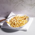 Assiette de frites de pommes de terre avec fourchette — Photo de stock