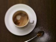 Cappuccino com açúcar polvilhado ao lado dele — Fotografia de Stock