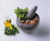 Mortier et pilon avec des ingrédients pour persil Pesto — Photo de stock