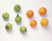 Green apples and oranges — Stock Photo