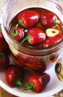 Peppers preserved in oil and garlic in jar — Stock Photo