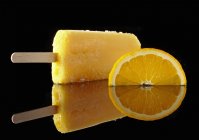 Вид крупным планом на апельсиновый леденец и кусочек апельсина — стоковое фото
