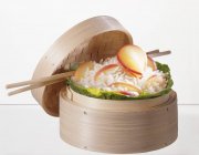 Reis mit Äpfeln im dampfenden Korb — Stockfoto